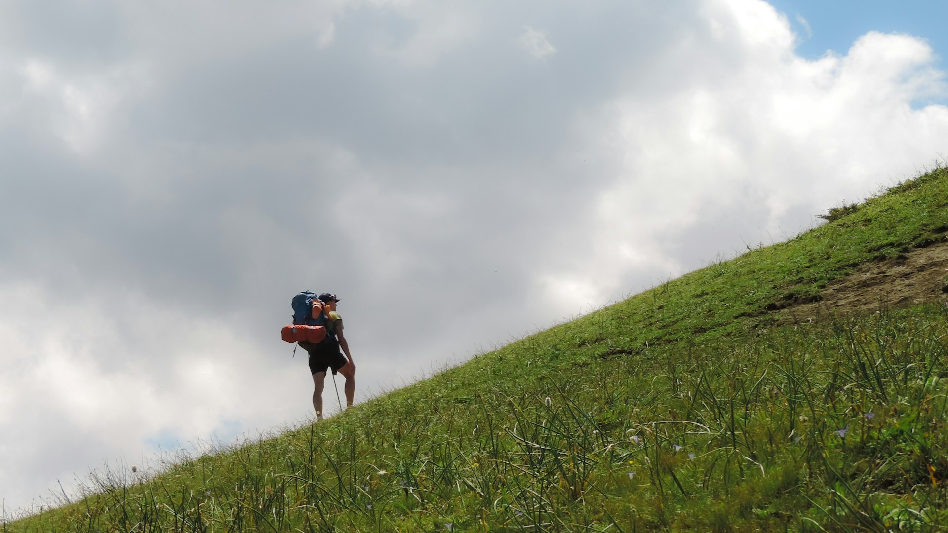 A person walking up a hill with a backpack